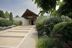 A traditional Japanese building with a wooden roof and a gravel pathway leading to it.