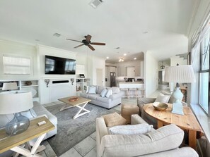 Relax in this inviting living space with a large flat-screen TV, comfortable seating area, and modern kitchen.