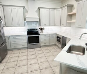 Effortlessly cook and clean in this well-equipped kitchen with a stainless steel range hood, dishwasher, and ample cabinetry.