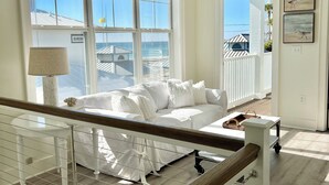 Un'ampia camera da letto con una grande finestra, un letto, un comodino e vista sull'oceano.
