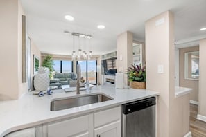 A modern kitchen with a dishwasher, a sink, and a dining area with a view. - Oceanfront 3rd Floor- King/Queen/Queen-Updated and Nicely Decorated Great Rates! (Myrtle Beach)