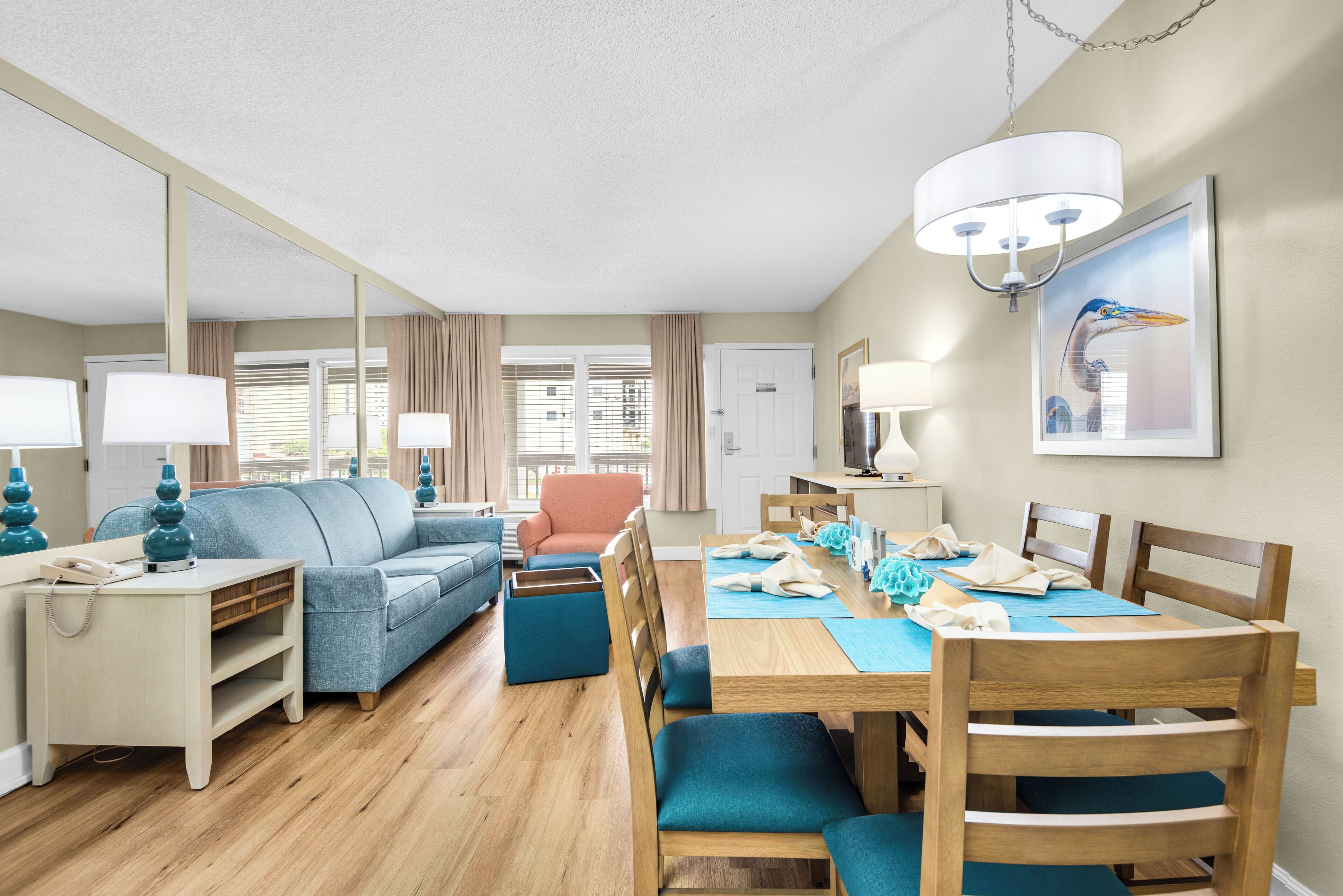 Un salon moderne comprenant un canapé, des fauteuils, une table à manger et une lampe.