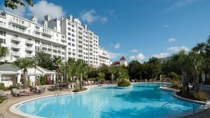 A hotel with a large swimming pool surrounded by palm trees and lounge chairs. - 1 bedroom, 2 Full bath condo in Sandestin  (Miramar Beach)