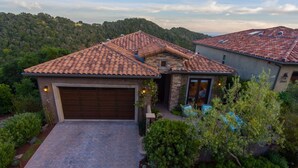 A house with a tiled roof, a garage, and a landscaped garden. - Experience Aloha Avila luxury executive home in San Luis Bay Estates (Avila Beach)