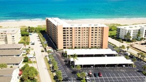 Un hotel a più piani con un parcheggio e vista sulla spiaggia.
