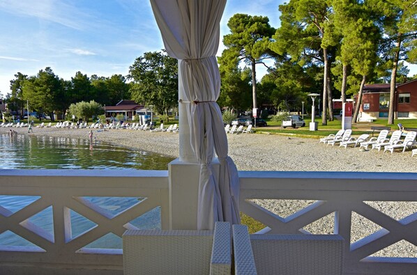 A beachside area with lounge chairs and a pool.