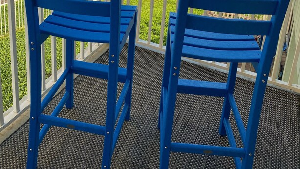 A balcony with two blue chairs overlooking a beach with waves. - Coastal Waters 214, 2nd floor 1 bedroom ocean view condo (New Smyrna Beach)