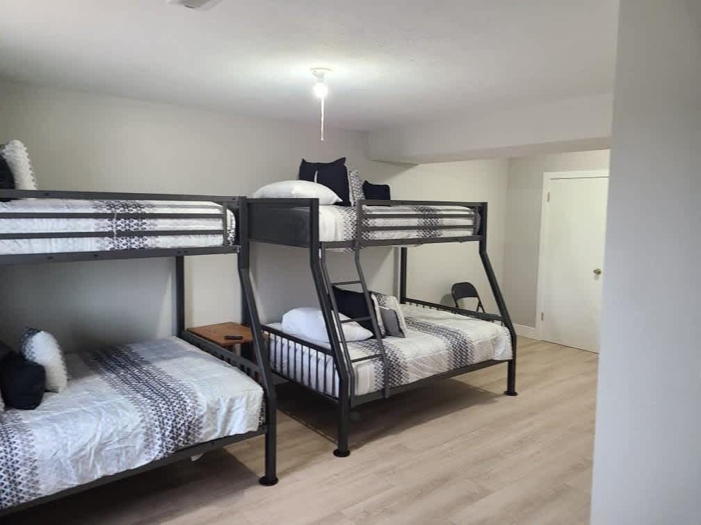 Una habitación con literas, una mesita y una lámpara en el techo.