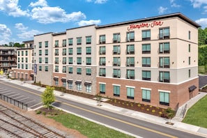 A Hampton Inn hotel with a modern design, multiple floors, and a parking lot.