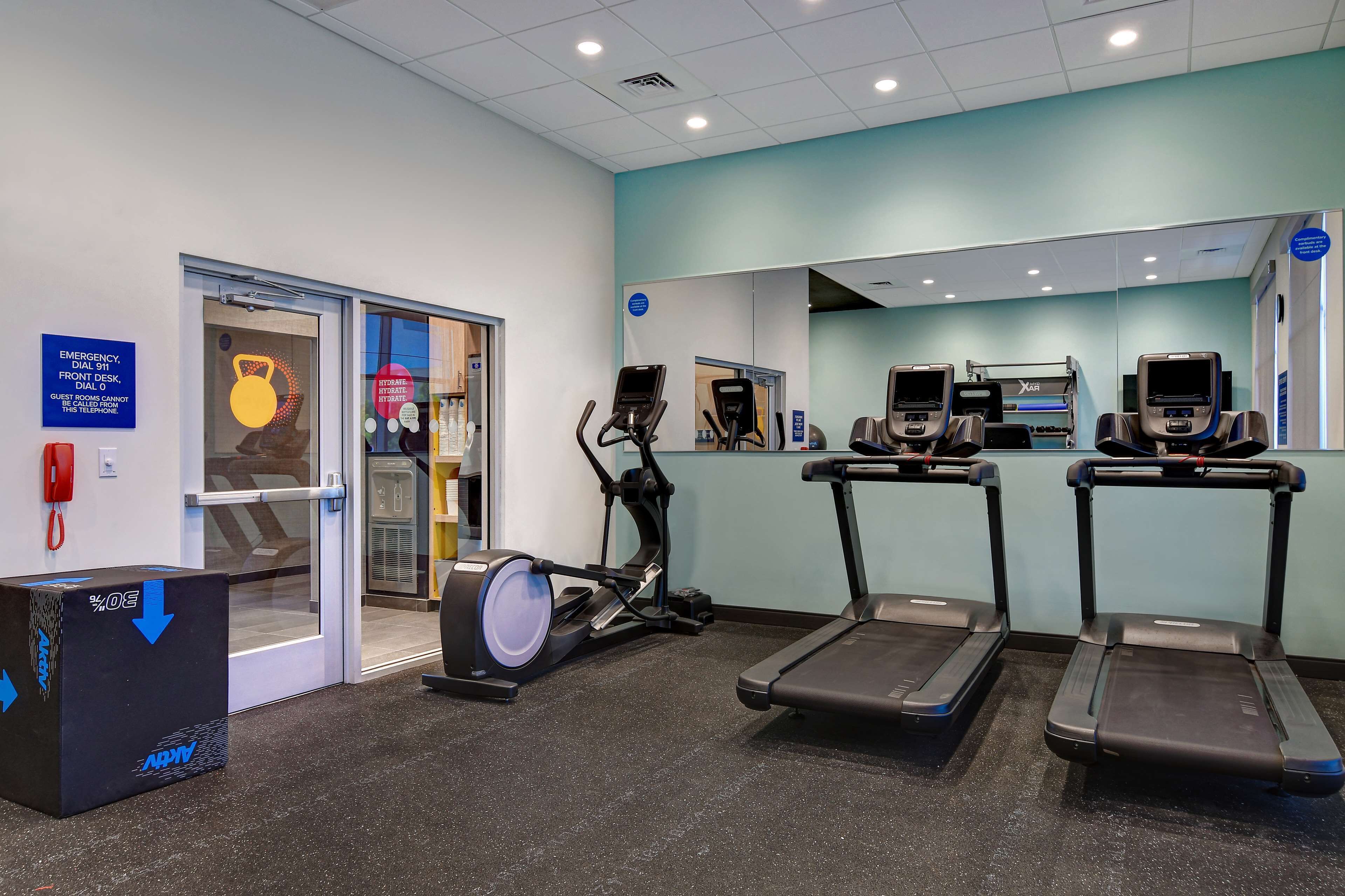 A fitness center with treadmills, an elliptical, and a punching bag.