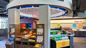A 24/7 market area with a variety of food and drink options, including a refrigerated section and a snack display. - Tru by Hilton Rocky Mount (Rocky Mount)