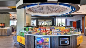 A self-service kiosk with a variety of snacks and beverages, a refrigerated section, and a digital display. - Tru by Hilton Rocky Mount (Rocky Mount)