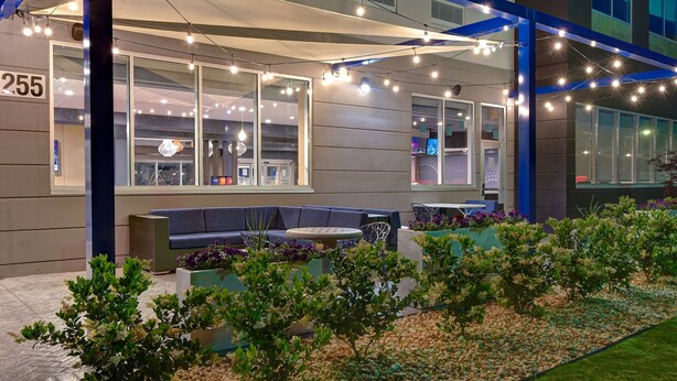 A modern building with a number '255' sign, outdoor seating area, and string lights. - Tru by Hilton Rocky Mount (Rocky Mount)