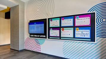 A wall with various signs and a digital display.