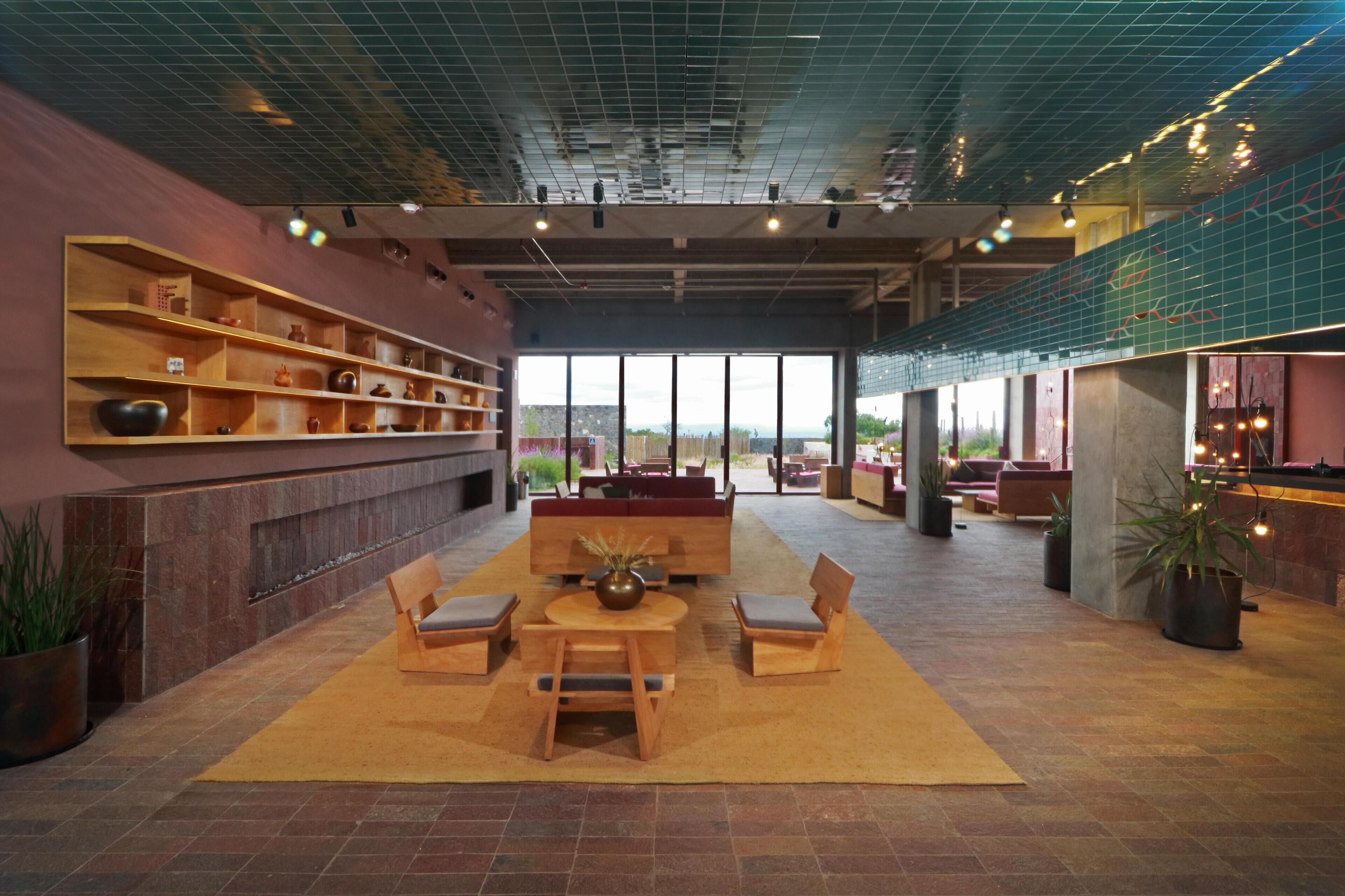 A spacious lobby with a large seating area, a fireplace, and a view through large windows.