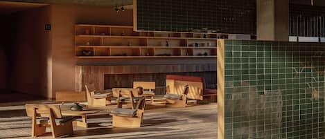 A modern interior with wooden furniture, a tiled wall, and a ceiling with exposed beams.