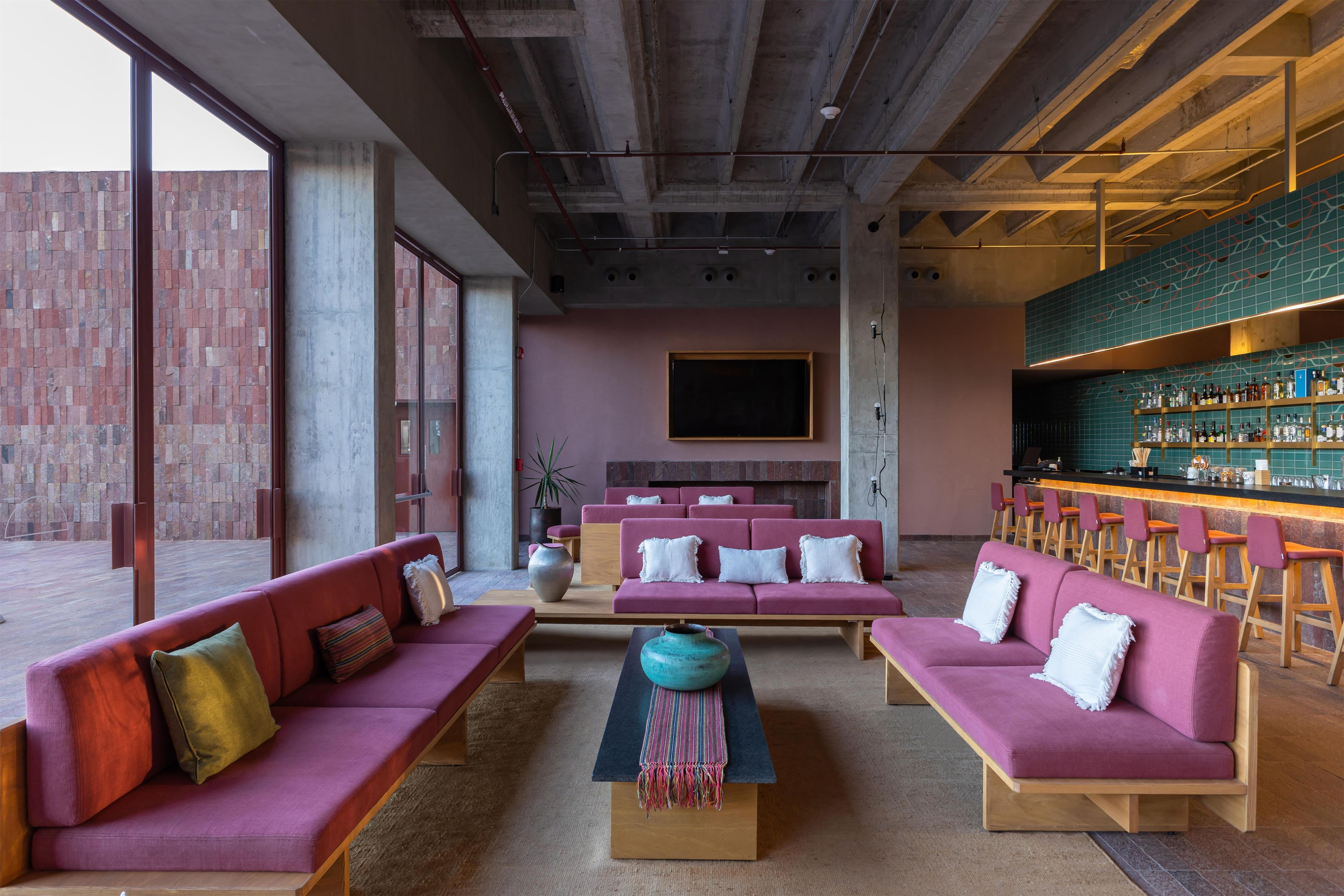 Eine moderne Lounge mit Sofas, einer Bar und einem großen Fenster.