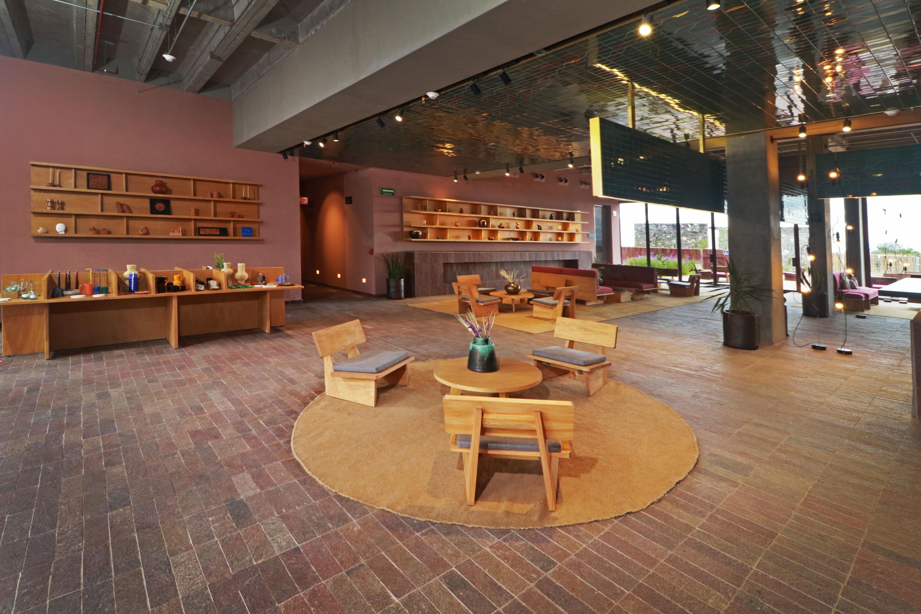 A spacious lobby with a central seating area, wooden furniture, and a large bookshelf.