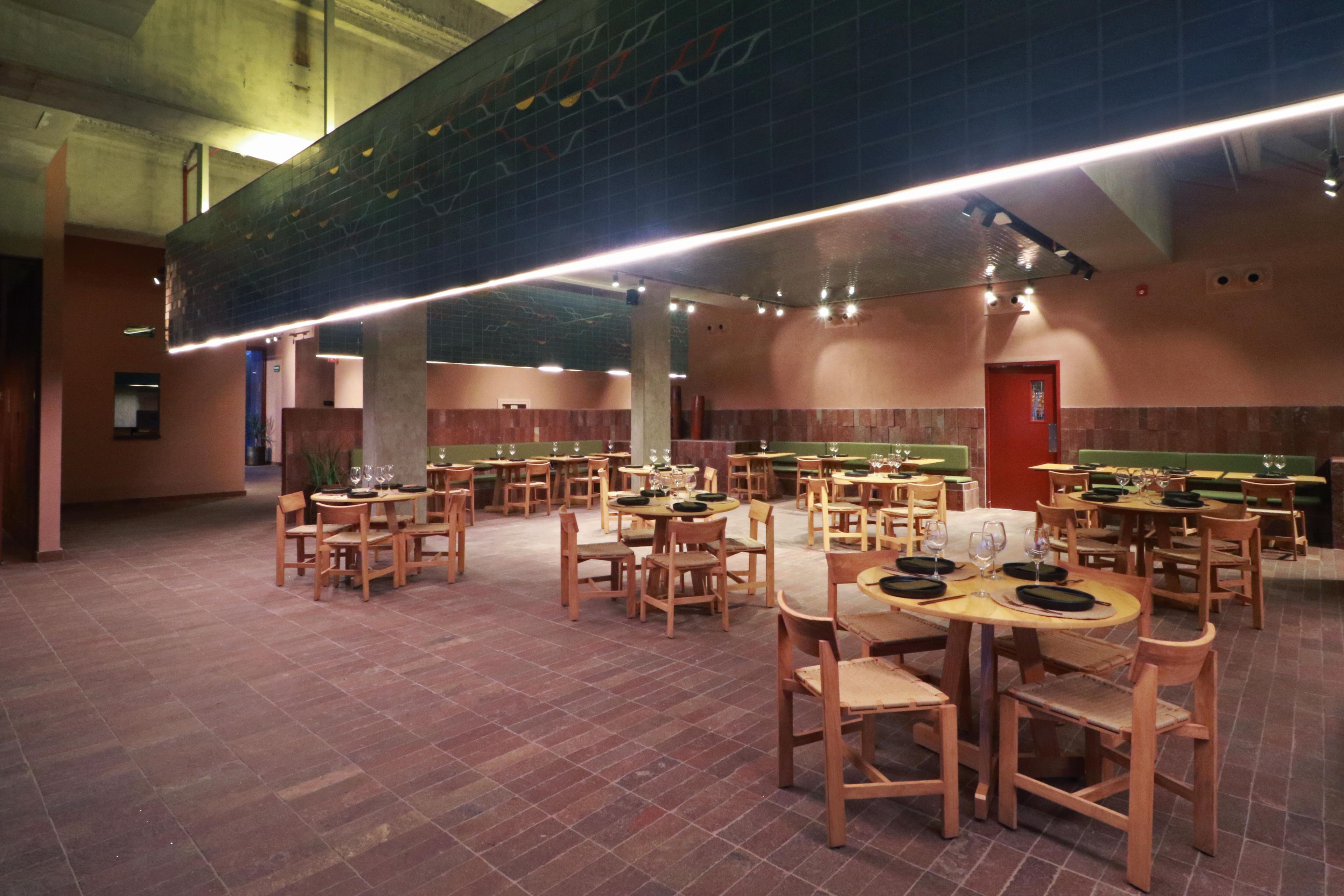 A spacious indoor dining area with multiple tables and chairs, high ceilings, and a modern design.