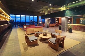Un vaste espace de détente avec des coins salon, un bar et de grandes fenêtres offrant une vue panoramique.