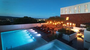 A rooftop pool area with multiple hot tubs and lounge chairs, surrounded by a modern building with a view of the cityscape. - Albor San Miguel de Allende, Tapestry Collection by Hilton (San Miguel de Allende)