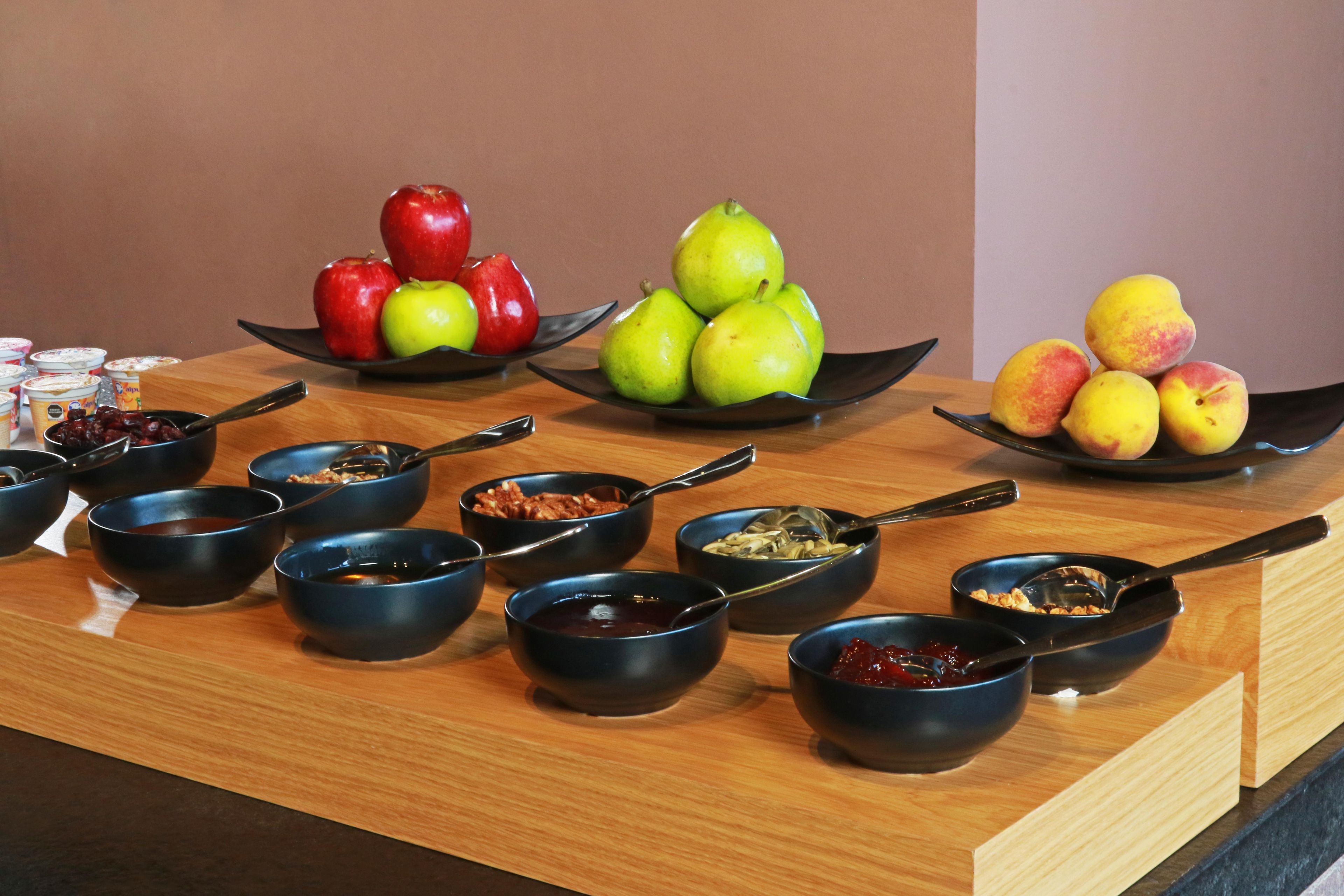 A breakfast buffet with various fruits and bowls of food.