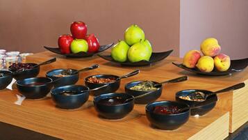 A breakfast buffet with various fruits and bowls of food.