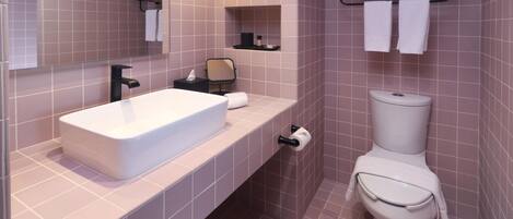 A modern bathroom with a white sink, a toilet, and a mirror.