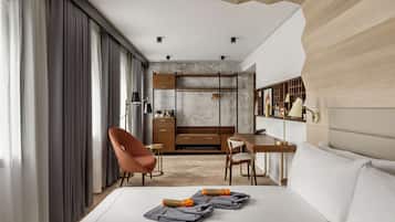 Een moderne hotelkamer met een bed, een bureau, een stoel en een kledingkast.