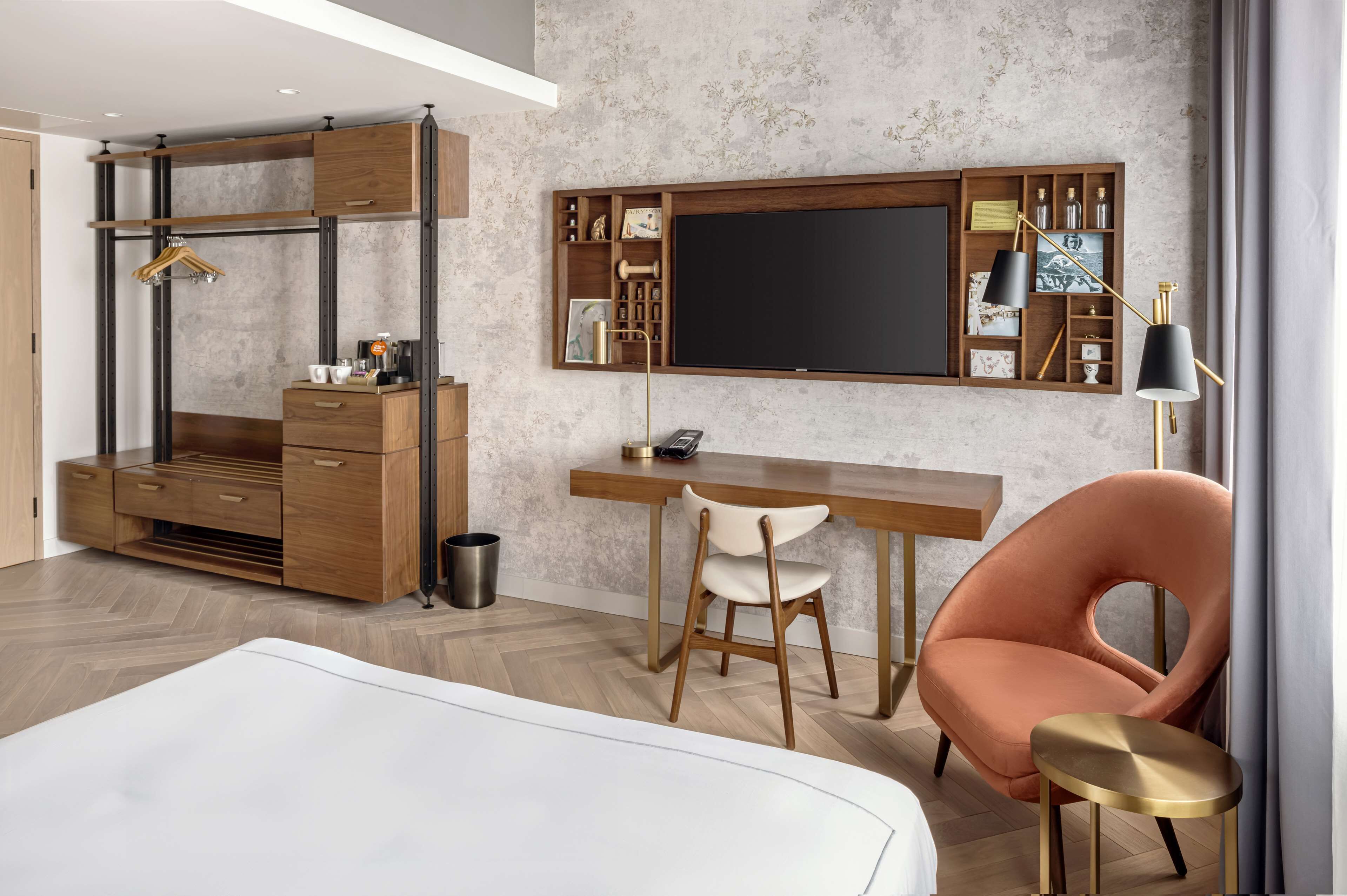 Un dormitorio moderno con cama, escritorio, silla y armario.