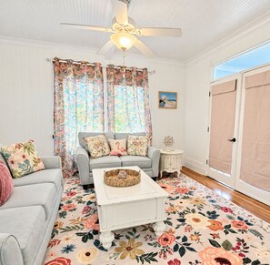 Sala de estar com sofá, mesa de centro e ventilador de teto.