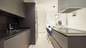 A modern kitchen with dark cabinetry, a stainless steel sink, and a built-in oven. - Mayor Suite 8 by FeelFree Rentals (San Sebastián)