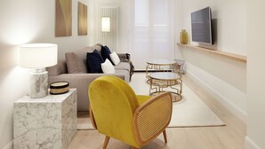 A modern living room with a sofa, yellow armchair, and two round tables. - Mayor Suite 8 by FeelFree Rentals (San Sebastián)