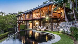 A large, modern house with a spacious outdoor area, including a swimming pool and outdoor seating.