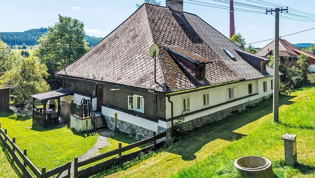 A traditional house with a sloped roof, a wooden porch, and a stone pathway leading to the entrance. - Lenora II by Interhome (Lenora)