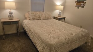 A bedroom with a large bed, two bedside tables, a window with blinds, and wall-mounted lamps. - Quite and cozy / Boat ramp nearby.  (Minster)