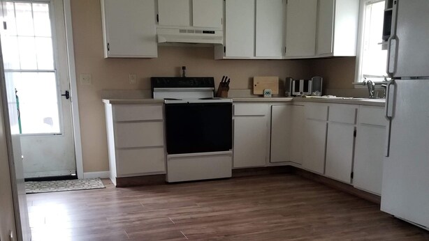 A kitchen with white cabinets, a stove, and a refrigerator. - Quite and cozy / Boat ramp nearby.  (Minster)