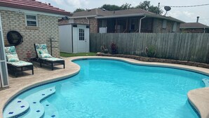 A swimming pool with a tiled edge, a wooden deck, and lounge chairs. - 🌹Southern’s Beauty 1🌹 (Kenner)