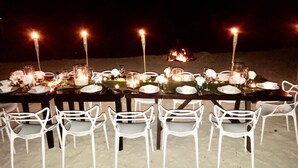 A beachside dining setup with tables and chairs arranged for guests.