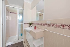 Een bad/douchecombinatie, een haardroger, handdoeken, zeep