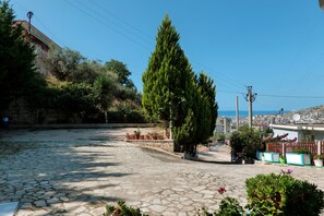 Surrounded by lush greenery and a tall tree, this serene courtyard offers a peaceful escape.