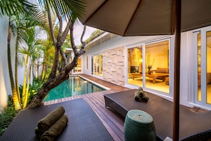 A poolside area with a lounge chair, a small table, and a decorative urn. - Splendid Private Villa, 2 BR, Canggu With Staff (Canggu)