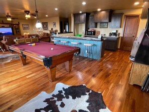 Relax and socialize in this inviting space featuring a pool table, bar area, and fully equipped kitchen.