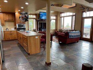 Relax in this inviting living area with a large island, sofa, and TV, offering a view of the outdoors.