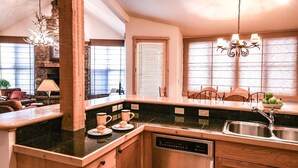 A kitchen with a built-in dishwasher, wooden cabinets, and a stone backsplash.