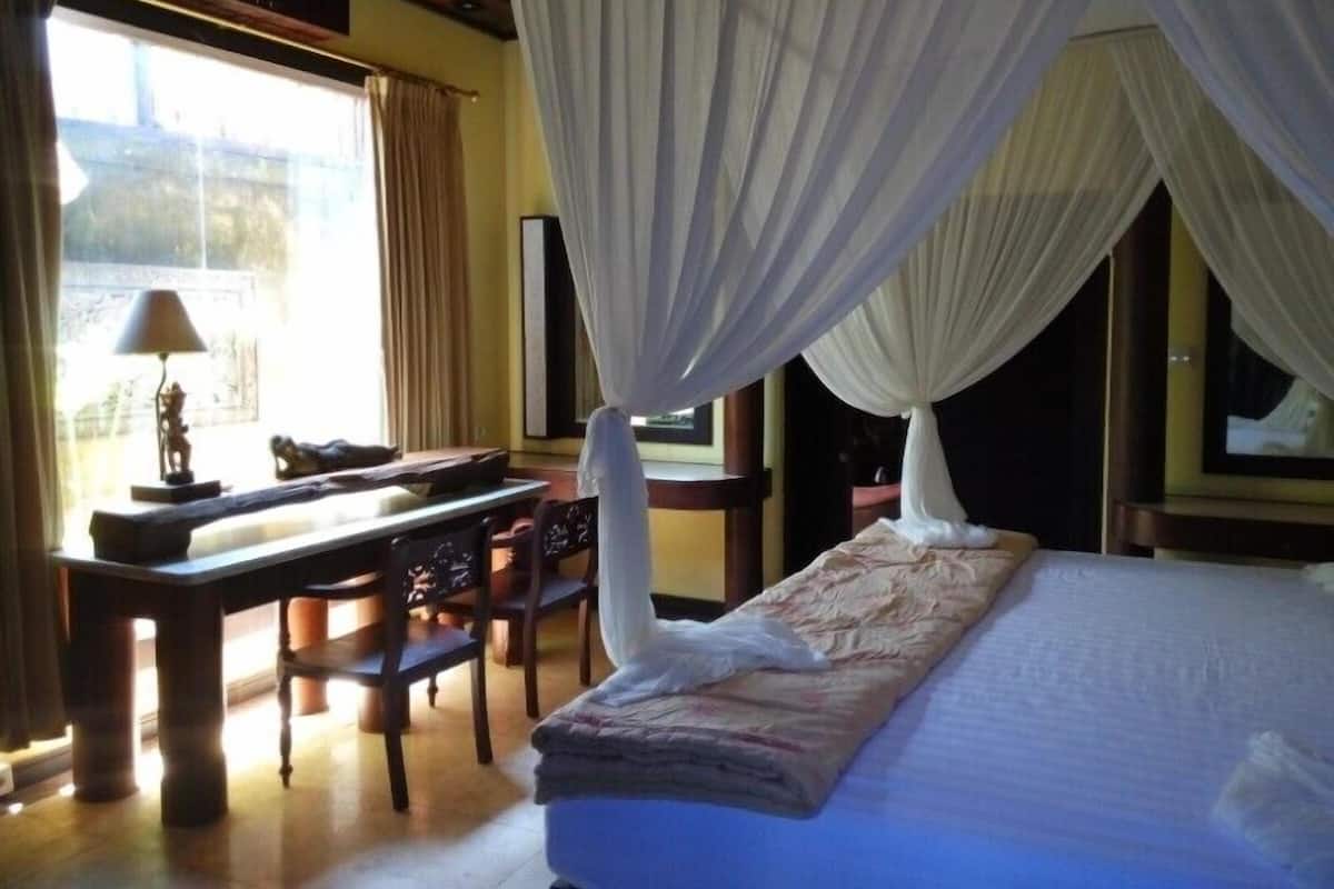 A room with a bed, a desk, and chairs.