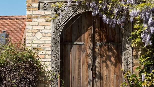 Un bâtiment en pierre avec une porte en bois et un petit escalier en pierre menant à l ’entrée.
