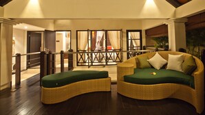 A spacious indoor area with wicker furniture and a view of a person in the background. - Harmony Villa Dua (Kerobokan)