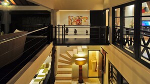A modern hotel interior with a staircase, a lounge area, and a dining space. - Harmony Villa Dua (Kerobokan)