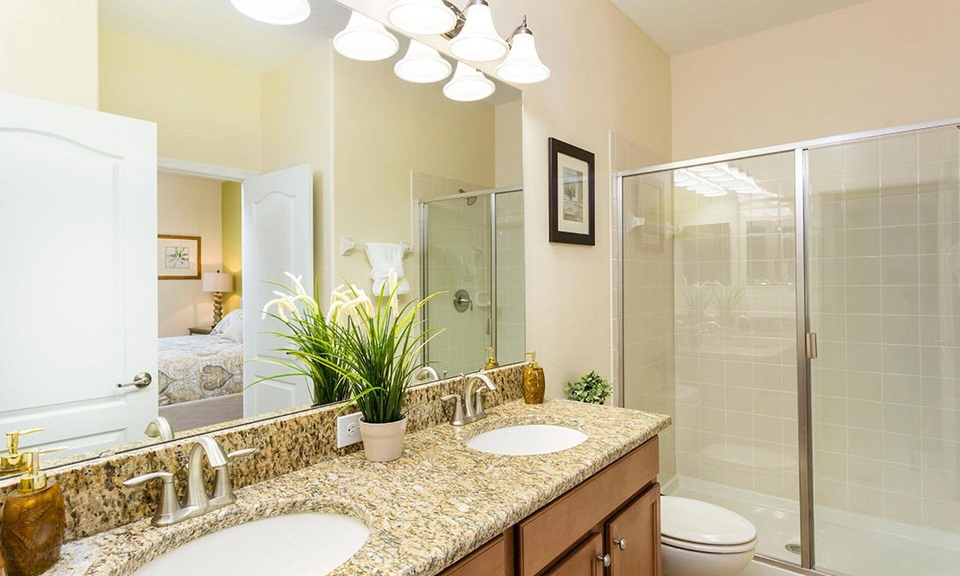 A bathroom with two sinks, a shower, and a large mirror.